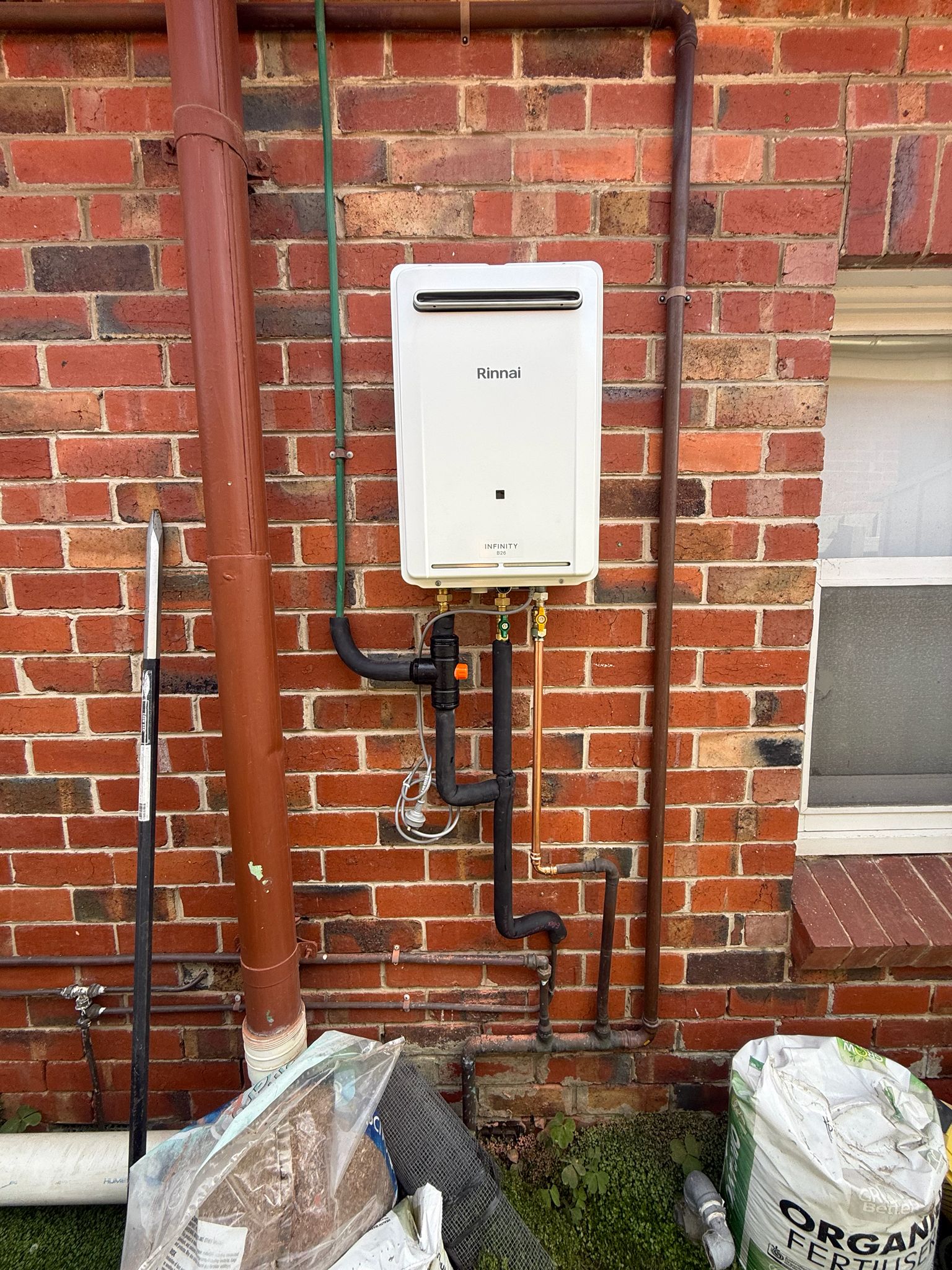 Rinnai continuous flow hot water system installed on red brick wall Fitzroy terrace Melbourne